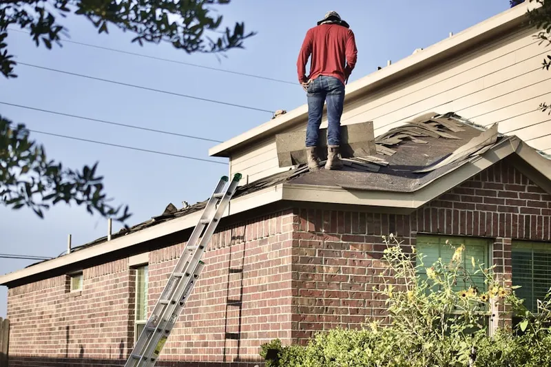 Professional roofer working on a residential roof in Warren Woods